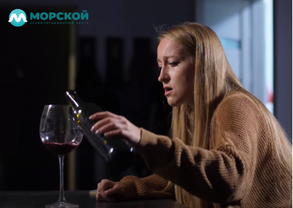 Женщина наливает вино в бокал